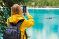 Tourist takes photo of stunning lake Braies in the Dolomite mountains with turquoise water