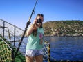 A tourist takes photographs during a Mediterranean cruise off the coast of Alanya, Turkey. A young adult girl holding a camera in