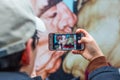 Tourist takes photos with famous kiss from Berlin Wall