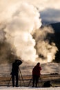 Tourist taking the explosion of old Faithful, Yellowstone in morning