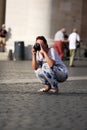 Tourist taking a photo crouching