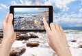 Tourist taking photo of crystal salt on Dead Sea Royalty Free Stock Photo