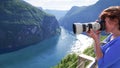 Tourist taking photo of fjord landscape, Norway