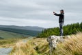 Tourist taking a photo at Glengesh Pass, mountain pass road in west Donegal between the heritage town of Ardara and the lovely Royalty Free Stock Photo