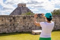 Tourist taking a photo at the Mayan pyramid temple of Kukulkan in Chichen Itza, the famous feathered serpent god of the Mayas Royalty Free Stock Photo