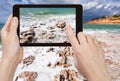 Tourist taking photo of salt beach on Dead Sea