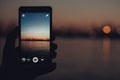 Tourist taking photo of sea harbor with mobile device at sunset Royalty Free Stock Photo