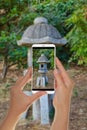 Tourist makes a photo of japanese garden lantern Royalty Free Stock Photo