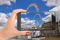 Tourist taking a photography with smartphone to London Eye on the banks of Thames River