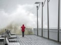 Tourist taking picture of big crashing wave hitting the pier Royalty Free Stock Photo