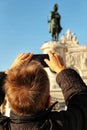 Tourist taking pictures of King Jose I equestrian statue in Lisbon