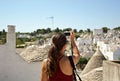 Tourist taking travel picture with mirrorless camera of Alberobello trulli cityscape during summer holidays. Unrecognizable female