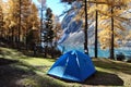 Tourist tent in the mountains on the background of the lake in autumn. Tourist tent in the Altai mountains. Tourism. Tourists.