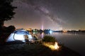 Tourist tent, two camping chairs and campfire on lake shore at night Royalty Free Stock Photo