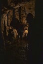 Tourist to the Sfendoni cave with stalactites, stalagmites and stalagnates underground