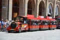 Tourist train at side of Palazzo dei Banchi in Piazza Maggiore.