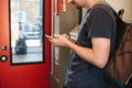 A tourist on the train uses a mobile phone.