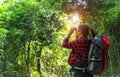 Tourist travel woman look binoculars on the in the forest.