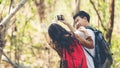 Tourist and traveler asian couple backpack enjoy happy take a photo selfie in the jungle forest nature park Royalty Free Stock Photo