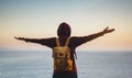 Tourist traveler with backpack standing with raised hands, hiker looking on sunset to valley in trip, hipster young girl enjoying Royalty Free Stock Photo