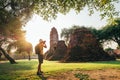 Tourist traveler with a backpack taking a photo of ancient Wat Ratchaburana Buddhist temple in holy ancient Ayutthaya city,