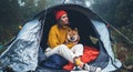 Tourist traveler in camp tent hugging red shiba inu on background froggy rain forest, hiker woman with puppy dog in mist nature Royalty Free Stock Photo