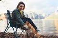 Tourist traveler drink tea girl relax together dog on mountain landscape, woman hug pet rest on lake shore nature