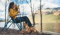 Tourist traveler girl drink tea leisure together dog on background mountain, puppy pet woman rest on lake shore nature trip