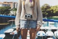 Tourist traveler photographer making pictures sea scape on vintage photo camera on background yacht and boat piar, hipster girl en Royalty Free Stock Photo