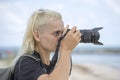 Tourist traveler photographer taking pictures of landscape on photo camera , hipster girl with backpack enjoying beautiful sea Royalty Free Stock Photo