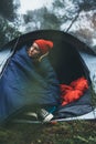 Tourist traveler ralaxing in camp tent in froggy mist forest, lonely hiker woman enjoy nature trip, green trekking tourism, rest