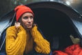 Tourist traveler ralaxing in camp tent in froggy mist forest, portrait lonely hiker woman enjoy nature trip, green trekking