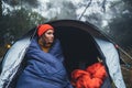 Tourist traveler ralaxing in camp tent in froggy rain forest, hiker woman enjoy mist nature trip, green trekking tourism, rest vac Royalty Free Stock Photo