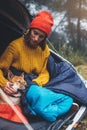 Tourist traveler relaxation red shiba inu in camp tent on background blue froggy forest, hiker woman with sleep puppy in mist