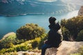 Tourist traveler sits on top mountain and enjoys river, hiker relax looking on blue sky clouds, background nature panoramic landsc