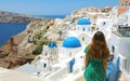 Tourist traveling in Santorini, Oia island in Greece, Europe travel summer vacation girl relaxing at view of three blue domes