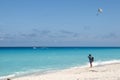 A tourist at a tropical beach photographs parasailing on the Sea in Mexico Royalty Free Stock Photo