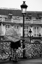 Tourist with umbrella by rainy day at bridge of Arts in Paris