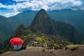 Tourist under red umbrella at Machu Picchu