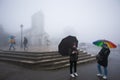 Tourist and Vietnamese people with umbrella in rainy and fog in