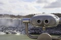 Tourist viewing binoculars at Niagara Falls with american waterfall in background Royalty Free Stock Photo