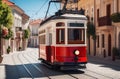 Tourist vintage red tram on the street on a sunny day, narrow streets, winding road, vacation, travel, tourism.