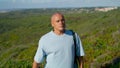 Tourist walk ocean view at green cliff edge in sunlight. Focused man hold yoga Royalty Free Stock Photo