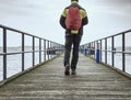 Tourist walk on wooden pier to the sea. Wooden bridge pier Royalty Free Stock Photo