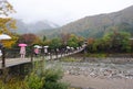 Tourist walking across thr bridge to Shirakawa go village during