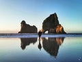 A tourist walking on a famous Wharariki beach on the South Island of New Zealand