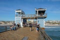 Tourist walking on the Oceanside Pier during blue summer day, Oceanside, northern San Diego County