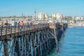 Tourist walking on the Oceanside Pier during blue summer day, Oceanside, northern San Diego County