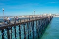 Tourist walking on the Oceanside Pier during blue summer day, Oceanside, northern San Diego County