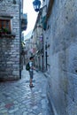 a tourist walking through the old town of Kotor in Montenegro, a street view of medieval European architecture, a journey through